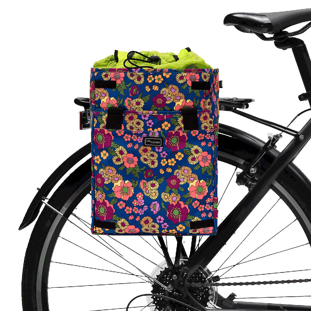 Floral-patterned bike pannier attached to a bicycle on a white background