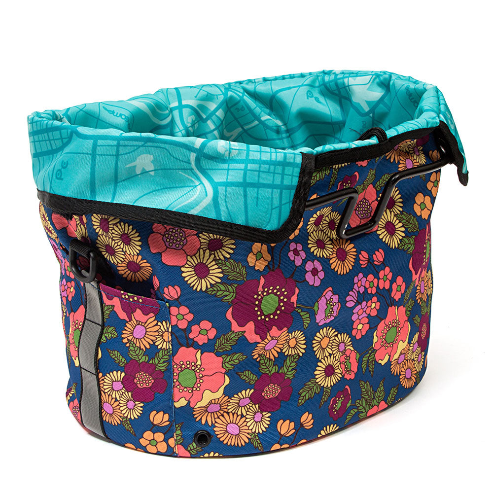 Multicolored floral-patterned bike basket with turquoise top section on a white background