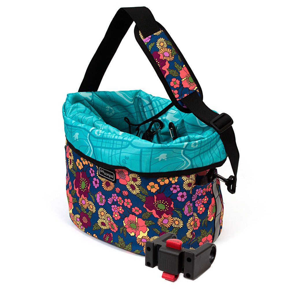 Floral-patterned bicycle bag with a turquoise top section on a white background