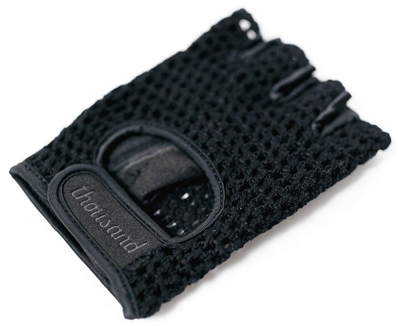 Black knitted glove with a strap and 'thousand' branding on a white background