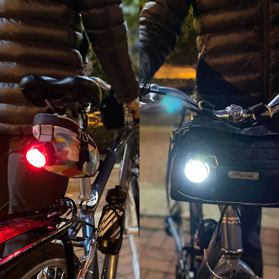 Bicycle with red tail light on left and front light on right, both in use.