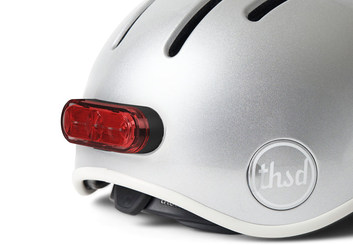 Close up of silver helmet with a red light on a chrome background