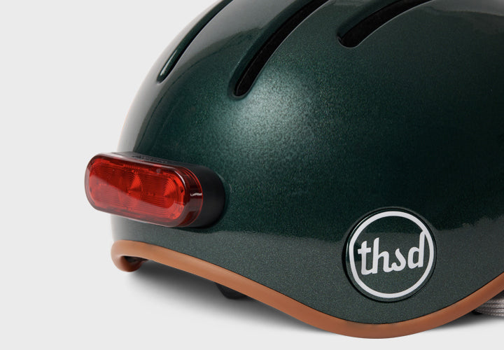 Green helmet with a red light and 'thsd' logo on a white background