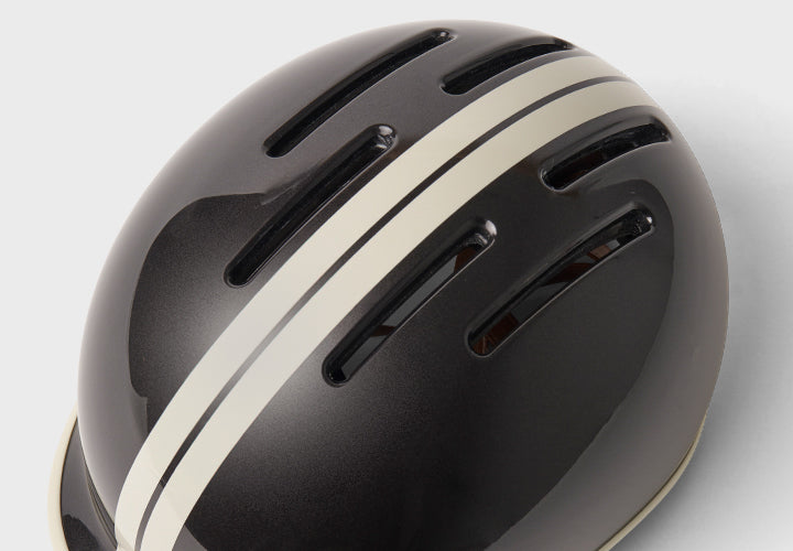 Black helmet with a white stripe on a light gray background