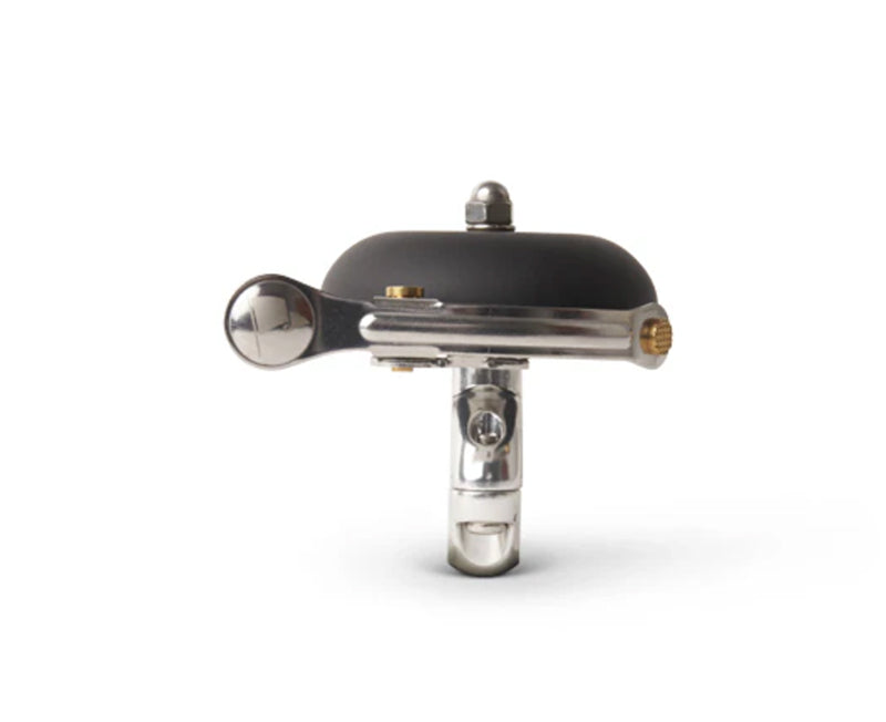 Vintage-style bicycle bell with black top and silver body on a white background
