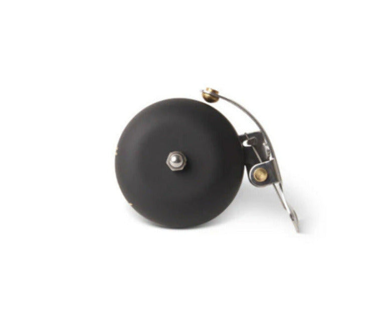 Matte black bicycle bell with metal components on a white background