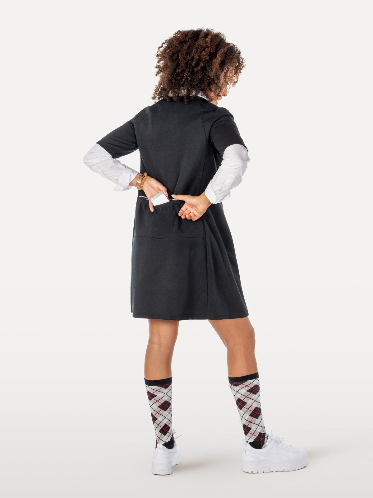 Black cycling dress over crisp white shirt showing back pockets with smart argyle kneesocks