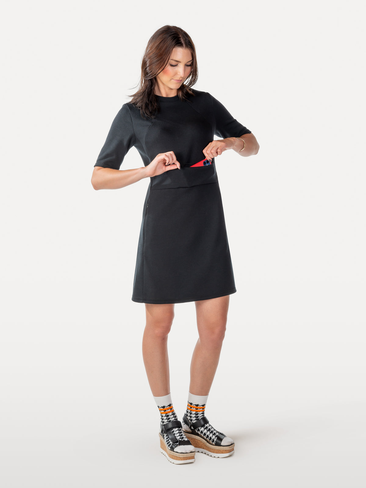 Universal black dress with elbow length sleeves showing hidden zippers over front pockets