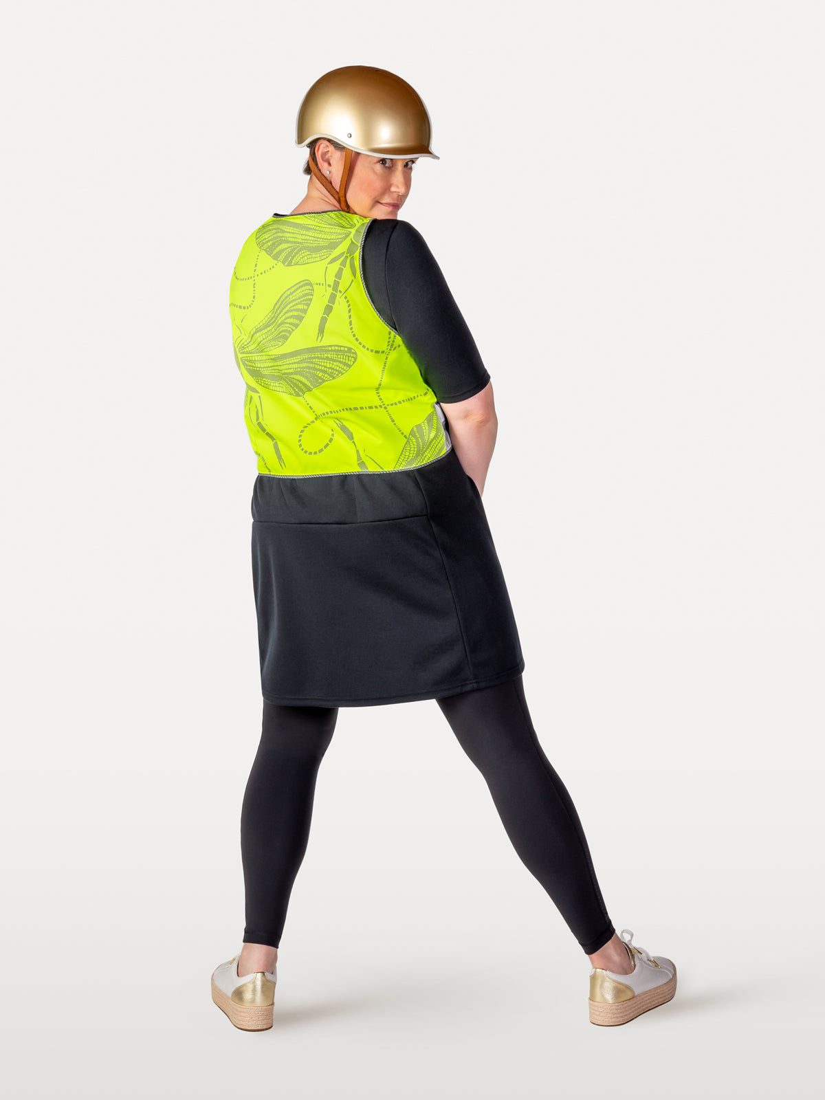 Dragonfly patterned reflective vest over black cycling dress and leggings.