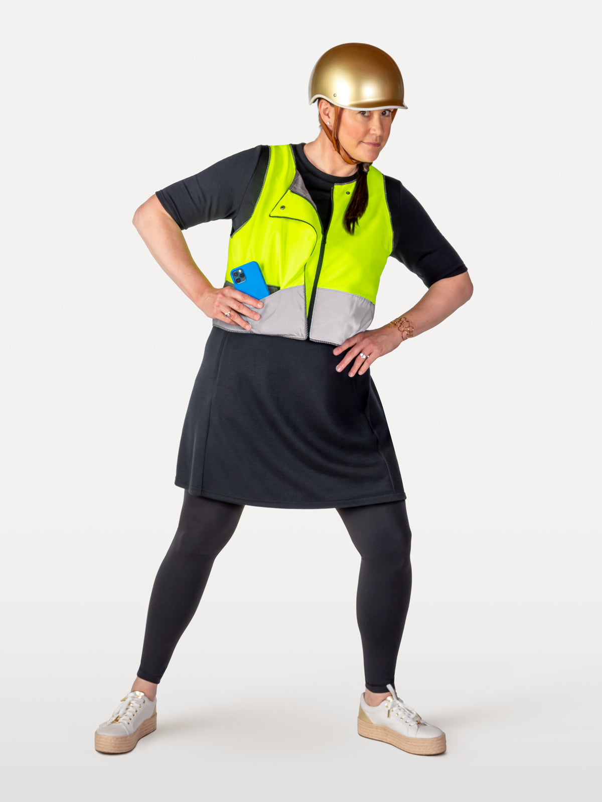 Solid black cycling dress under zippered reflective vest showing pocket for phone.