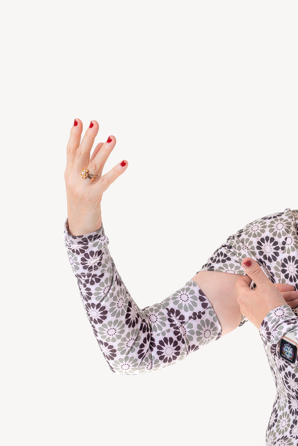 Person wearing a floral patterned arm warmer sleeve matching cycling dress.