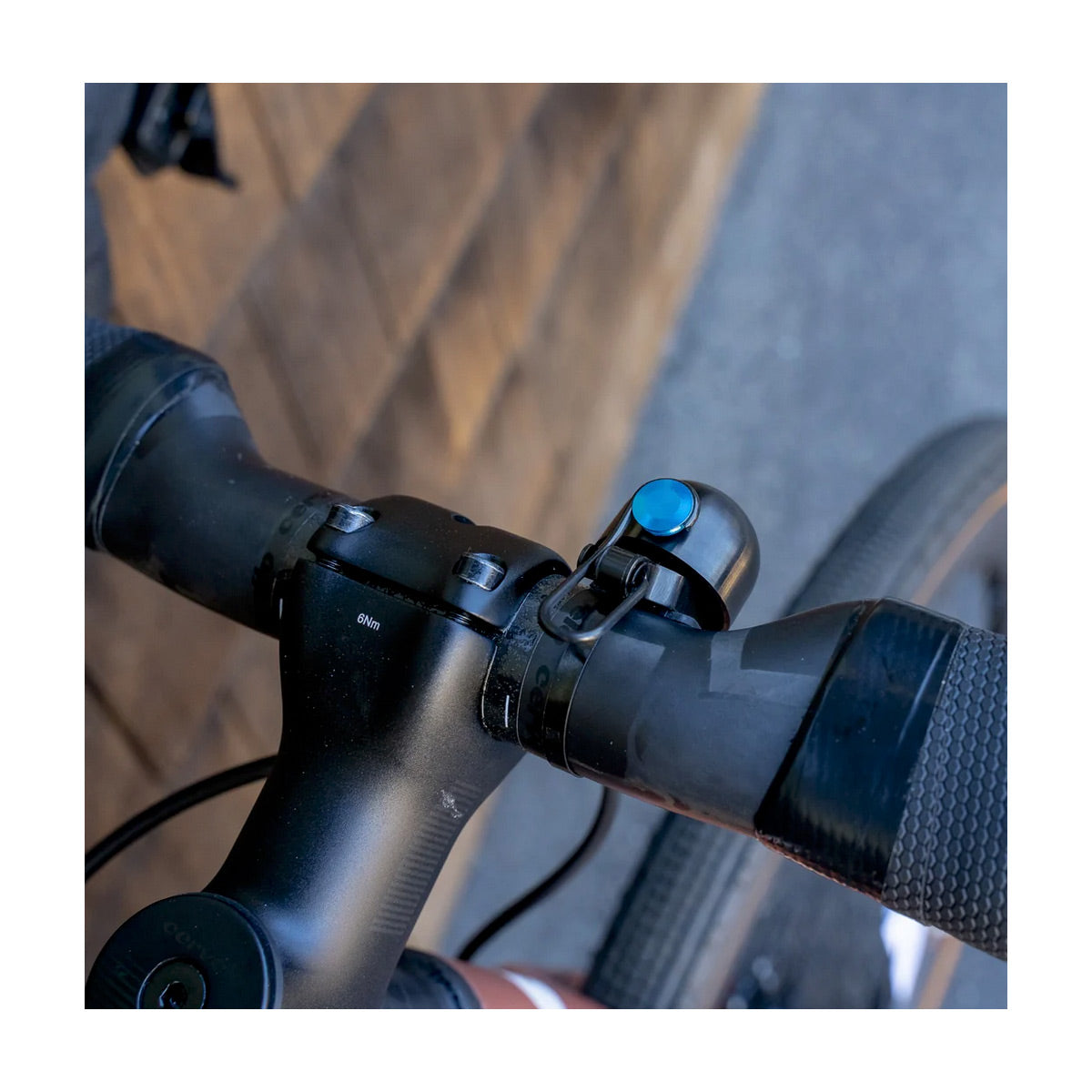 Close-up of a bicycle handlebar with a bell attached, blurred background