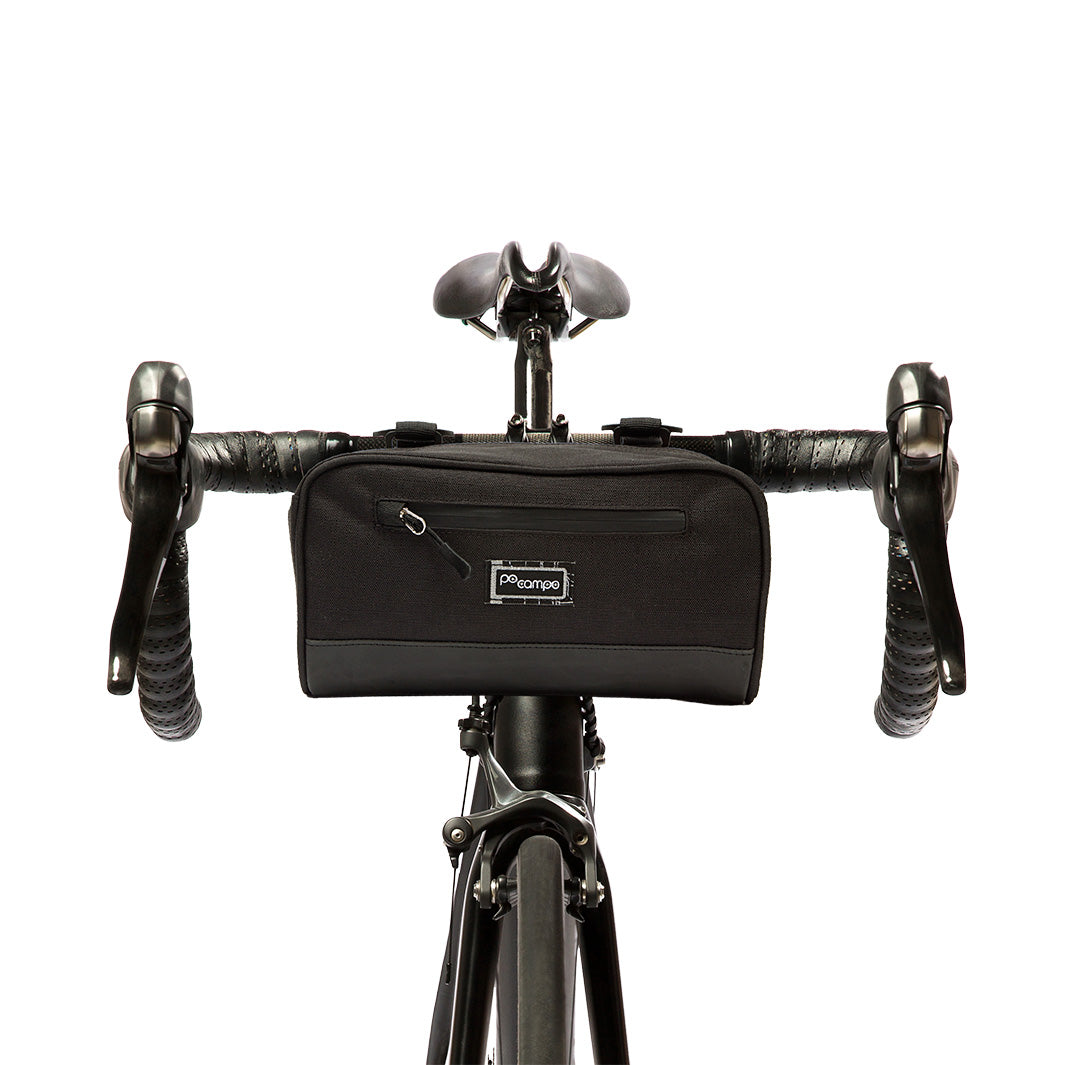 Black bicycle handlebar bag attached to a bike with a white background