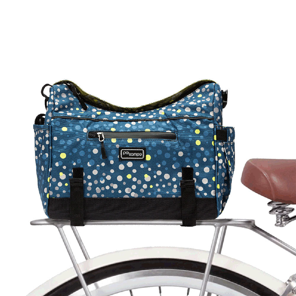 Blue polka dot Katy trunk bag attached to a bicycle rack on a white background