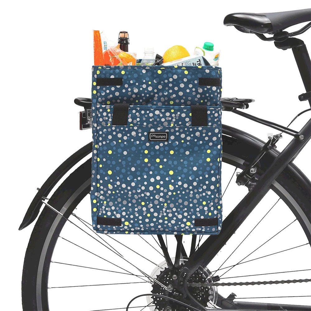 Bicycle grocery pannier with a blue polka dot pattern filled with groceries on a white background