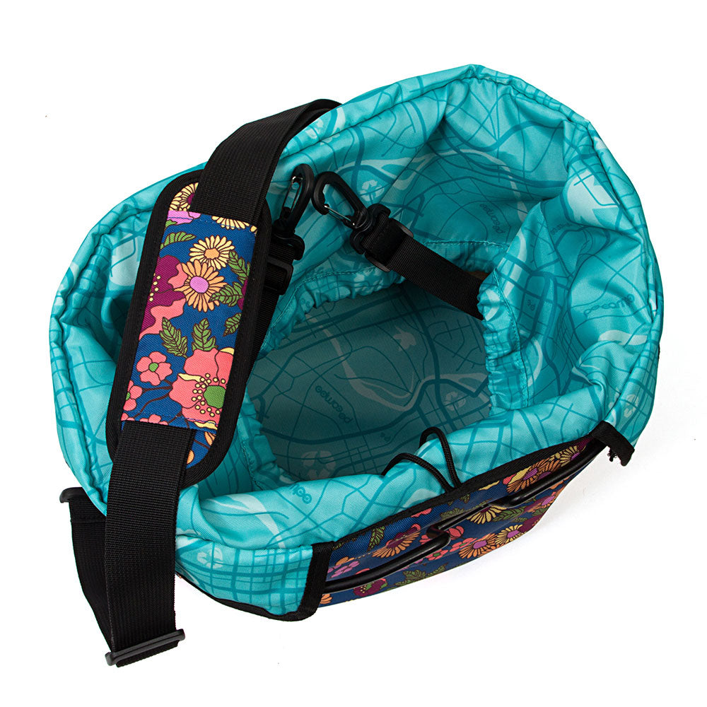 Turquoise drawstring bike basket with floral strap on a white background