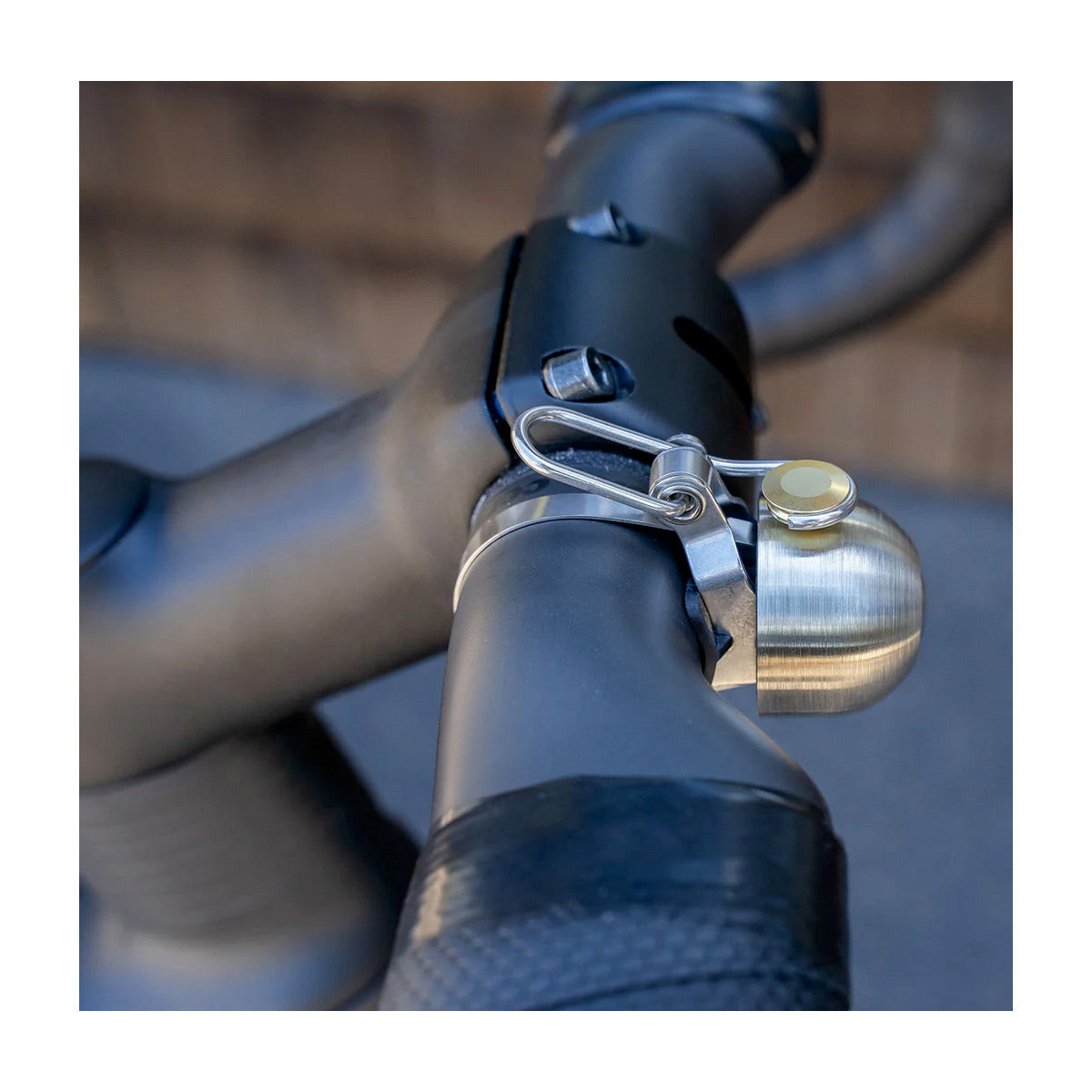 Close-up of a bicycle handlebar with a silver bell attached