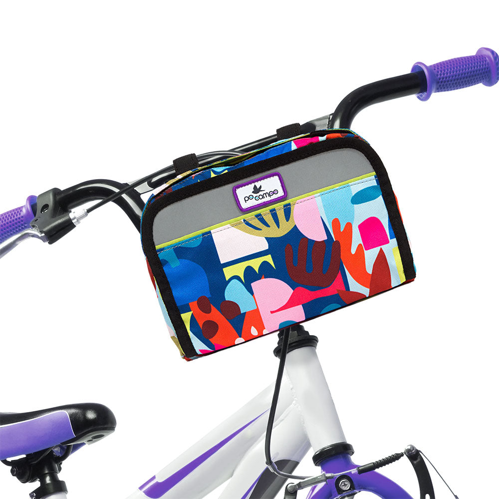 Colorful children's bicycle basket with abstract design attached to a bike frame.