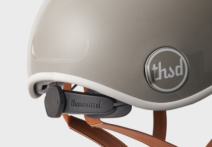 Close-up of a helmet with 'thsd' and 'thousand' branding on a white background