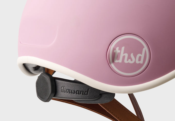 Pink helmet with 'thsd' logo and 'thousand' brand name on a white background