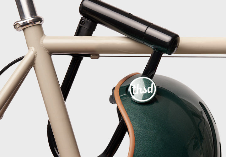 Close-up of a bicycle with a green helmet featuring a logo on a white background