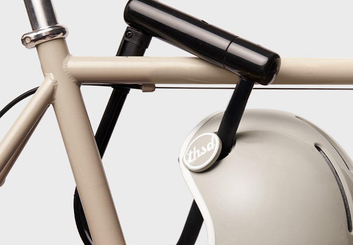Close-up of a bicycle with a helmet and bike lock on a light gray background