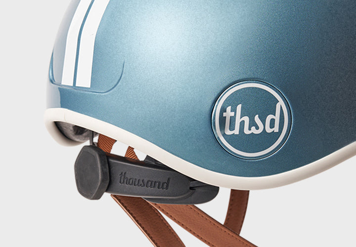 Close-up of a blue helmet with a Thousand logo on a white background