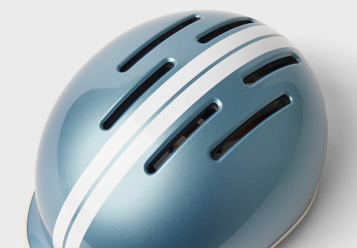 Blue helmet with white stripes on a light gray background