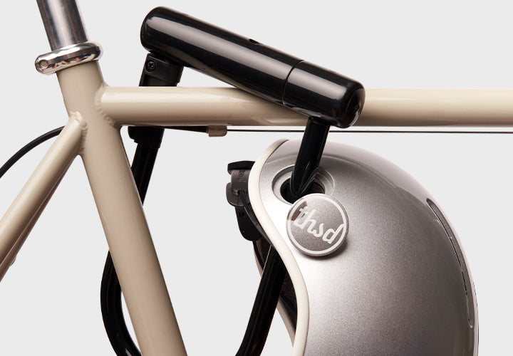Close-up of a bicycle with a helmet attached, featuring loophole design for bicycle lock.