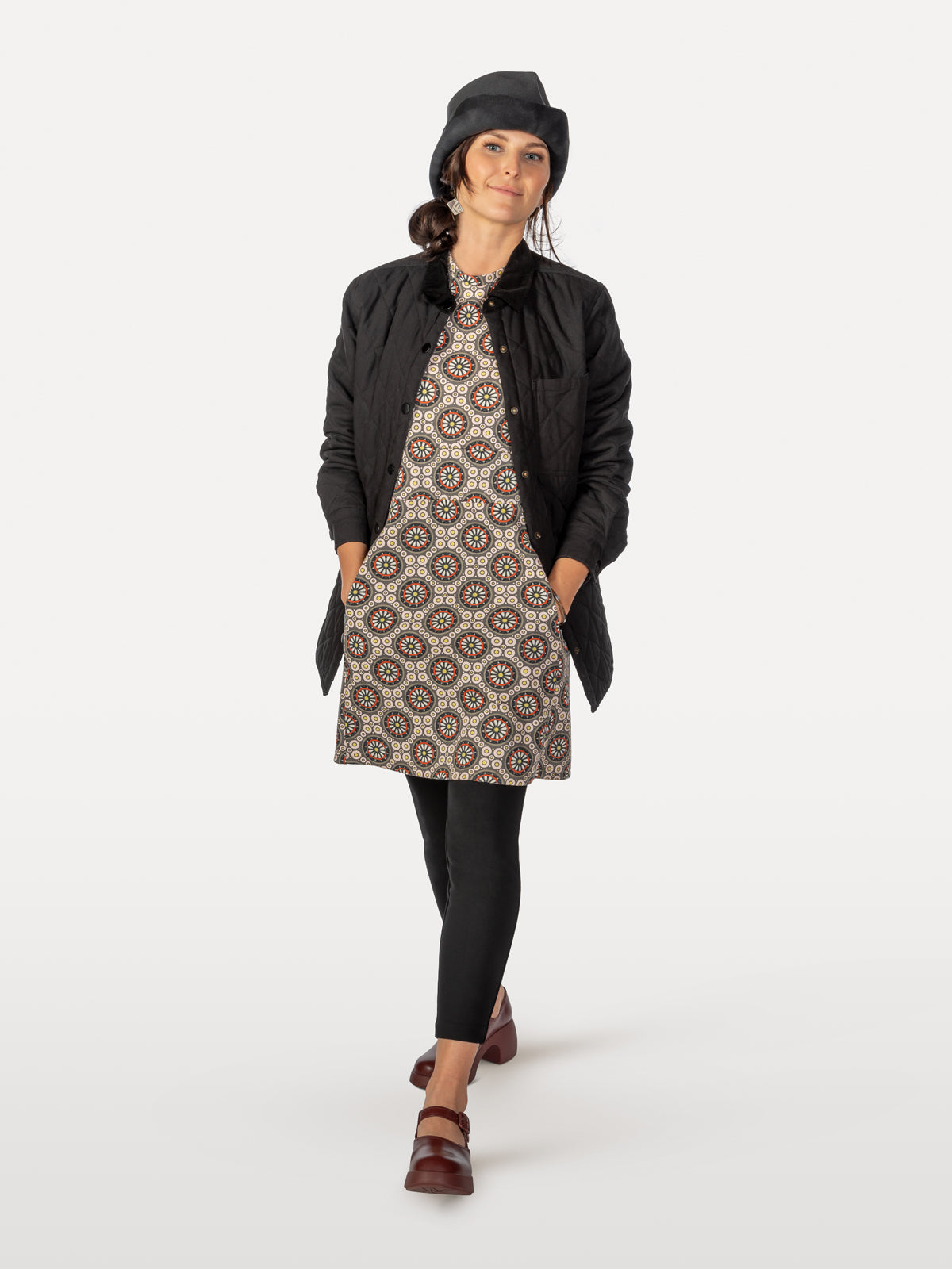 Bicycle-spoke patterned cycling dress under light fall black jacket and over black leggings