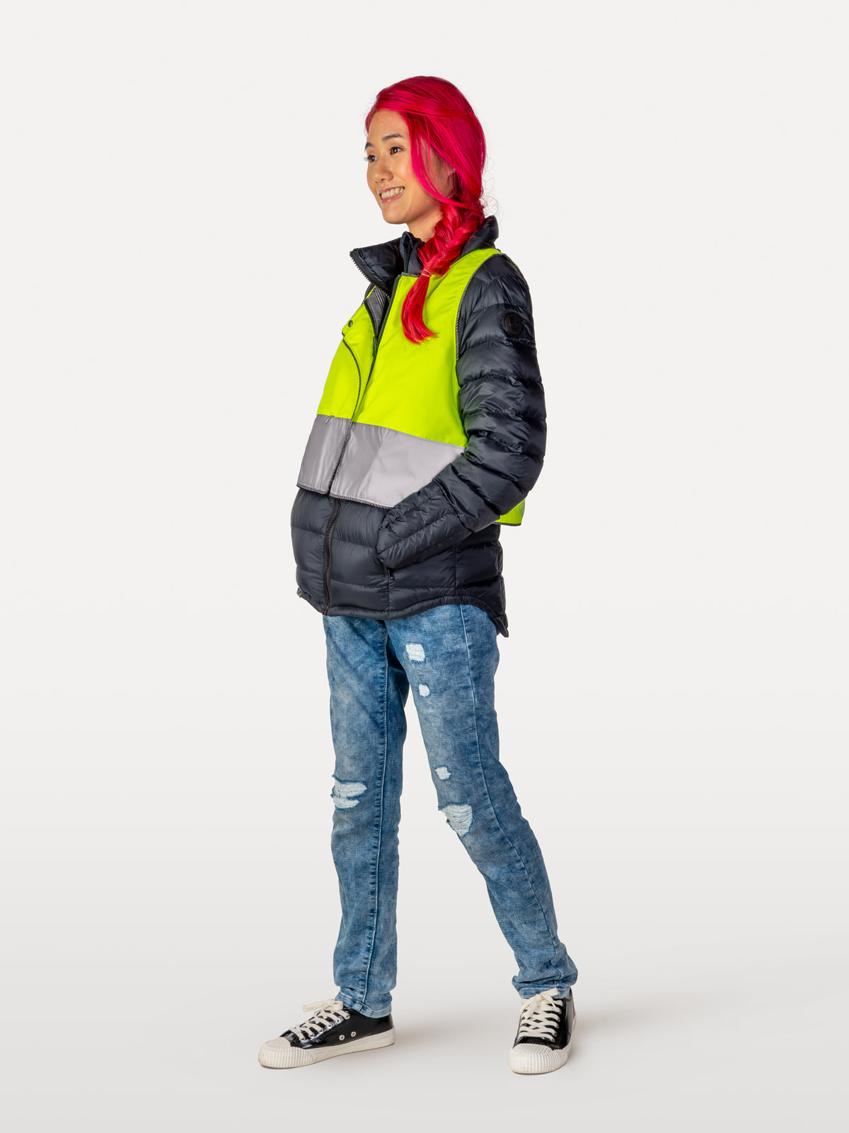 Zippered reflective vest over black down coat with flap open at top and zippered